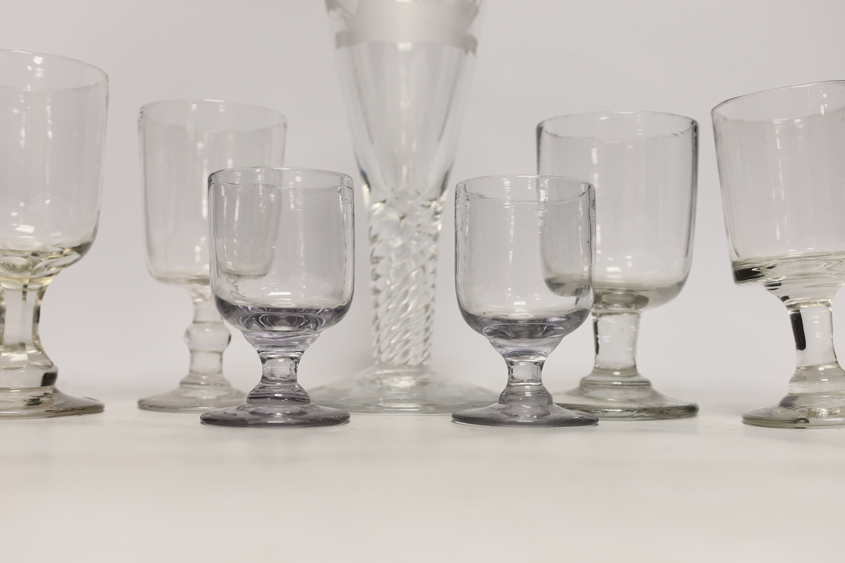 Eight 19th century drinking glasses including a large example with wrythen stem, etched with a naval ship, 27cm high